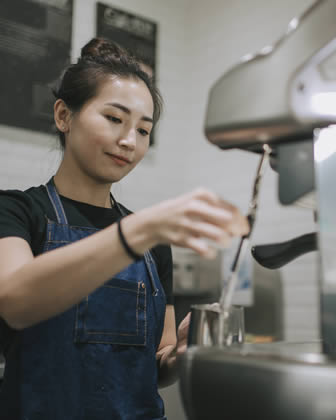 Barista making drink in coffee shop cafe